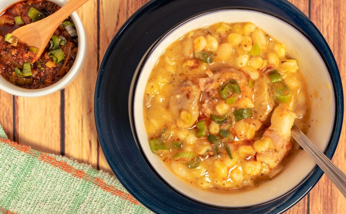 Plato de locro acompañado por salsita picante