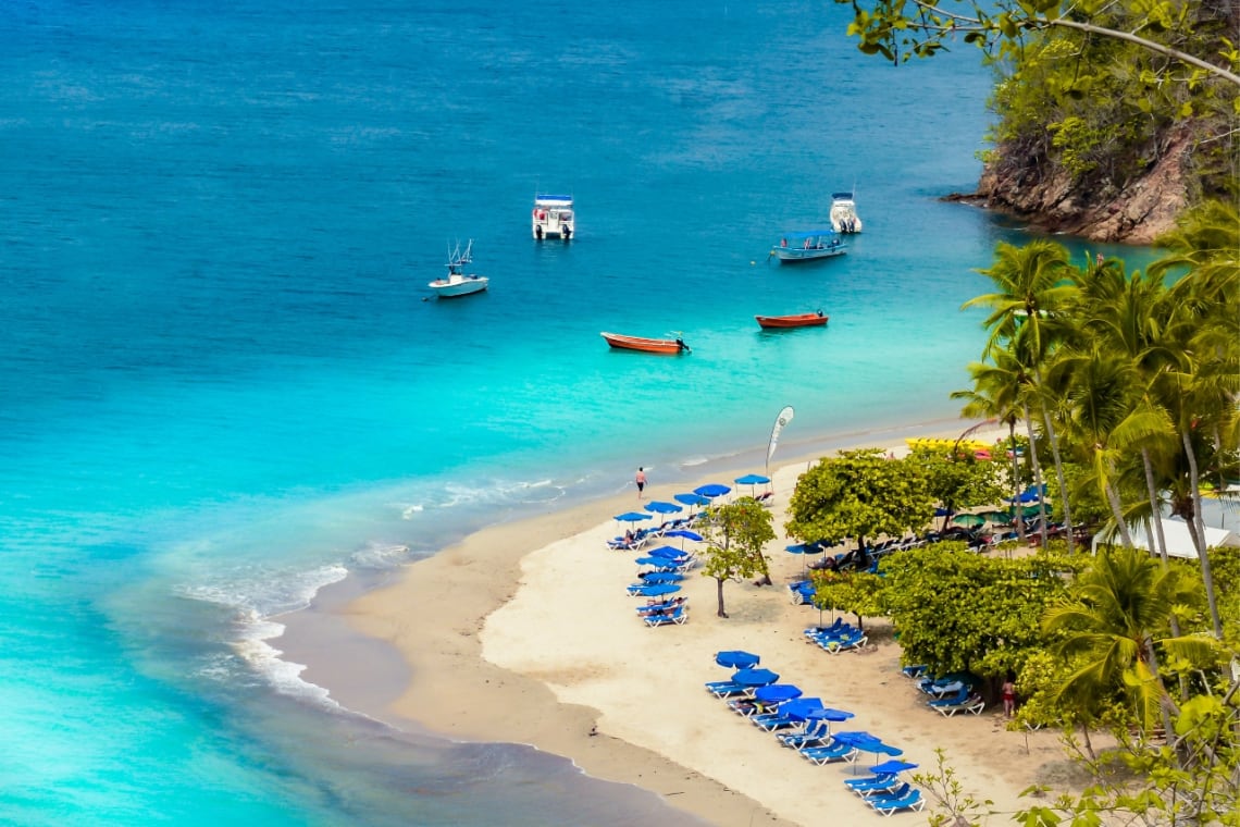 Agua turquesa y embarcaciones en la playa de Isla Tortuga
