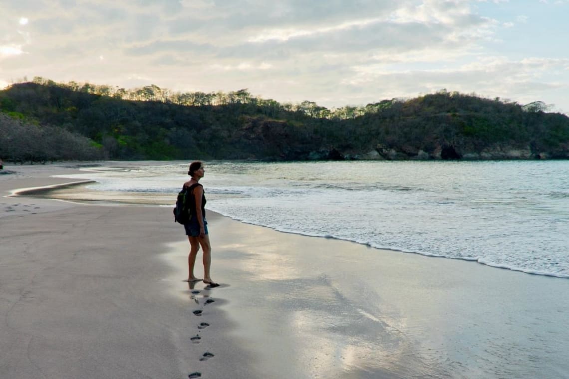 Chica caminando sola por una playa