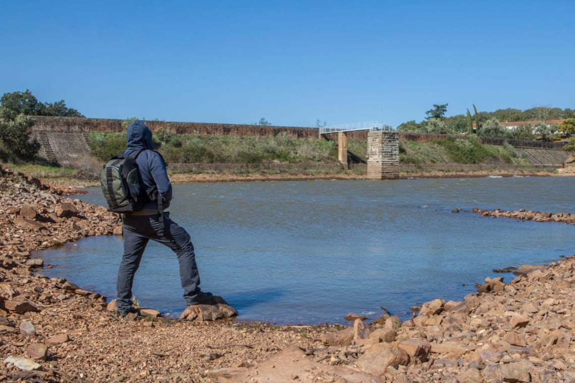 Joven con mochila mirando el embalse romano del Parque Natural Cornalvo