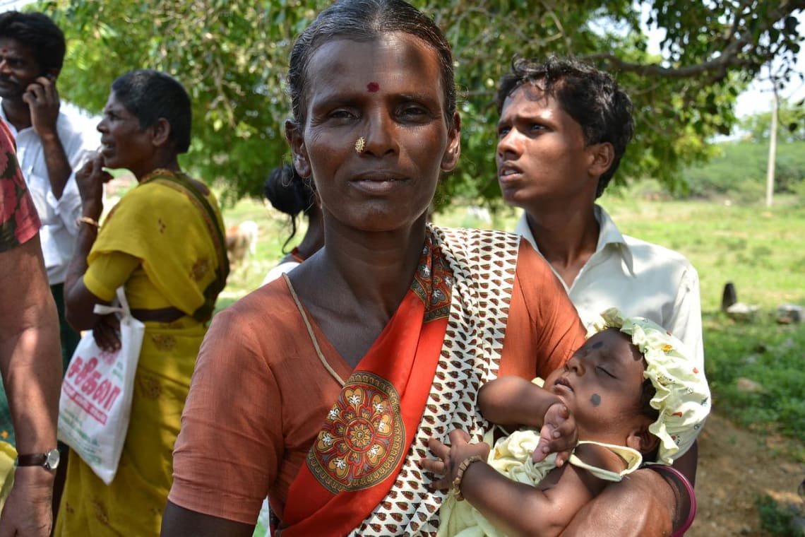 Woman from a rural community in India holding a baby
