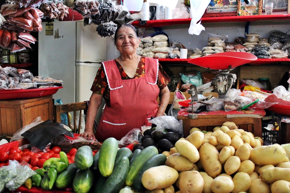 Mujer en un negocio de frutas en mercado mexicano