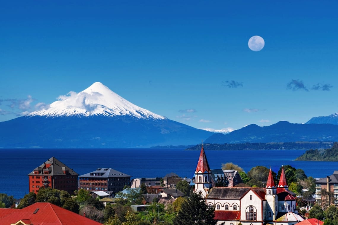 Edificios e iglesia de Puerto Varas con vista al lago y volcán Osorno nevado