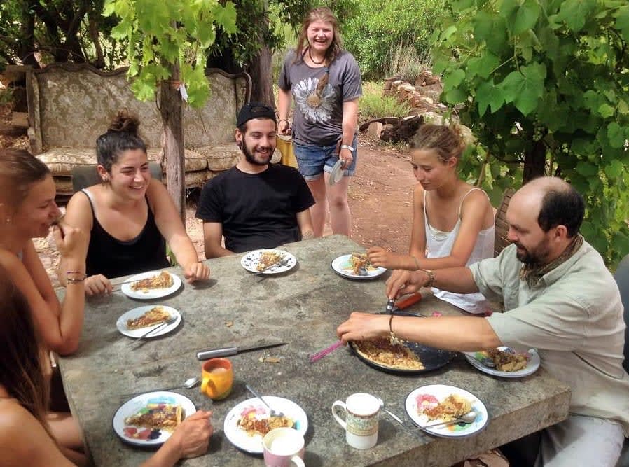 Host farmers and volunteers sharing a meal in Portugal