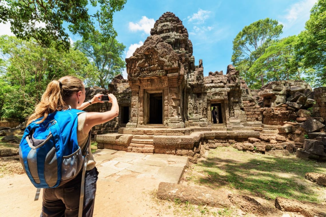 Viajes a Vietnam y Camboya: joven viajera tomando una foto de templo de Angkor