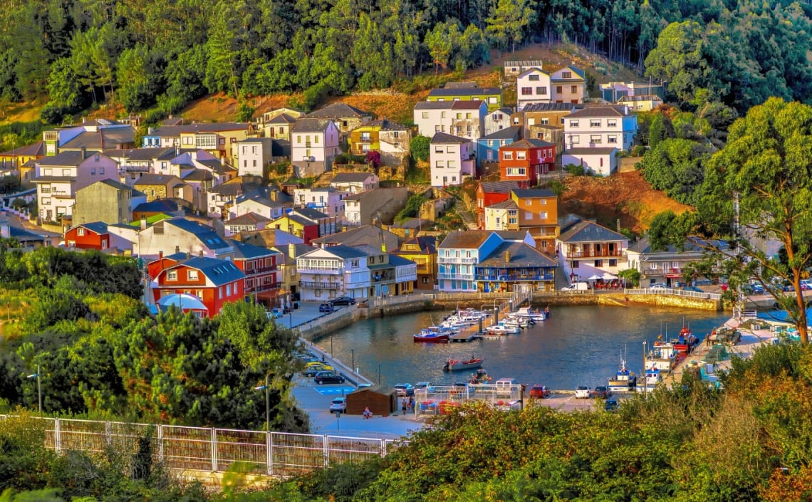 Casas coloridas frente a la ría en O Baqueiro, pueblo de Galicia, España
