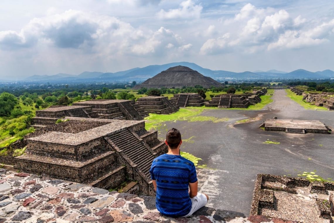 Joven sentado mirando las ruinas de Teotihuacán