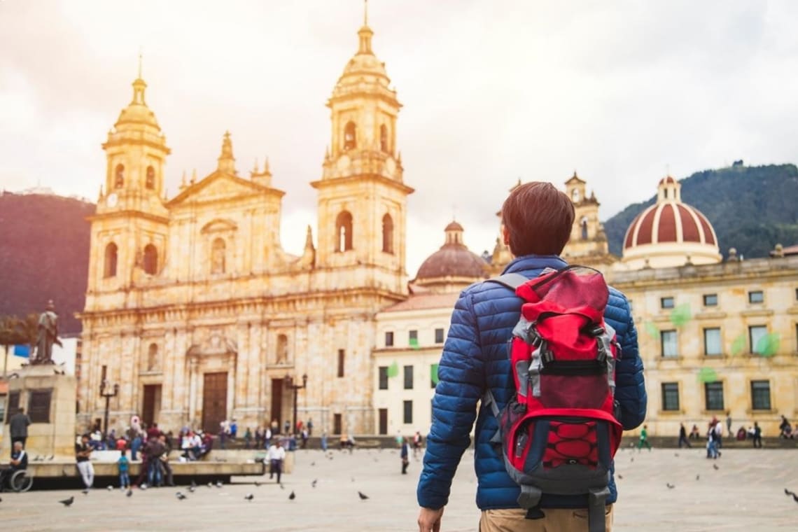 Joven mochilero en la plaza central de Bogotá,&nbsp;uno de los mejores destinos para viajar solo en Colombia