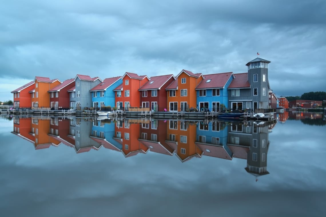 Colorful houses reflecting on a lake in Groningen