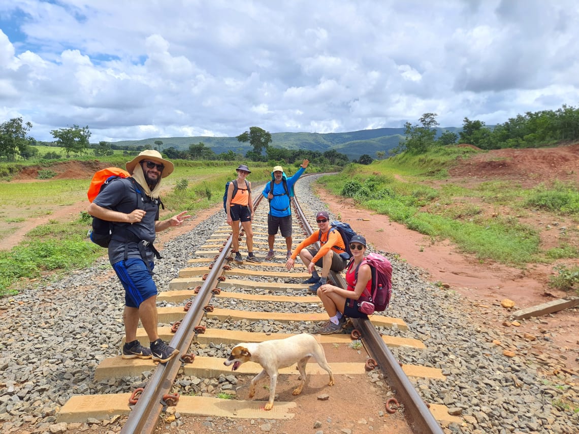 Caminhantes posam em trilho de trem no caminho de Cora Coralina