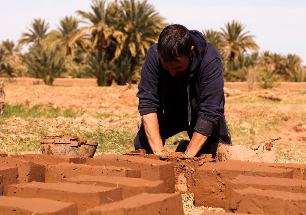 Joven haciendo ladrillos de adobe