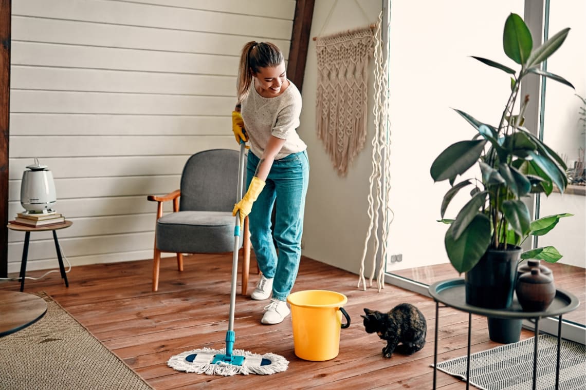 Girl mopping the floor during her long term house sittong experience