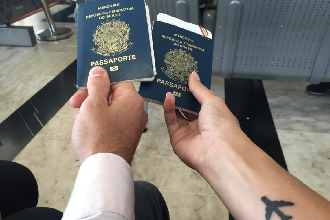 Requisitos para viajar a España: Mano de hombre y de mujer sosteniendo pasaportes de Brasil