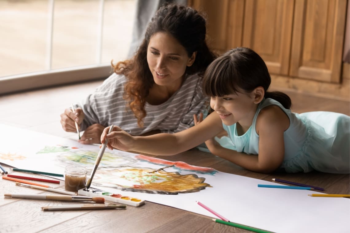 Mulher e criança fazendo uma pintura