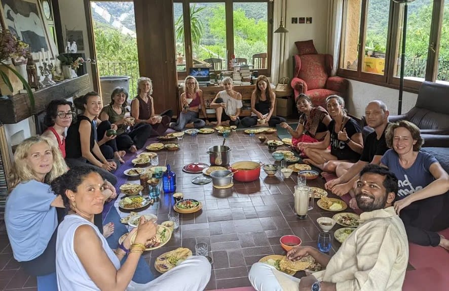 Group of volunteers eating in a circle at a yoga center in India