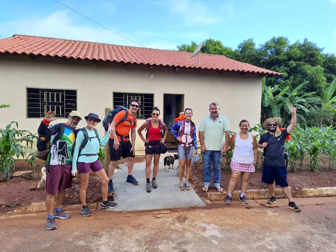 Viajantes posam em frente a hospedagem no caminho de Cora