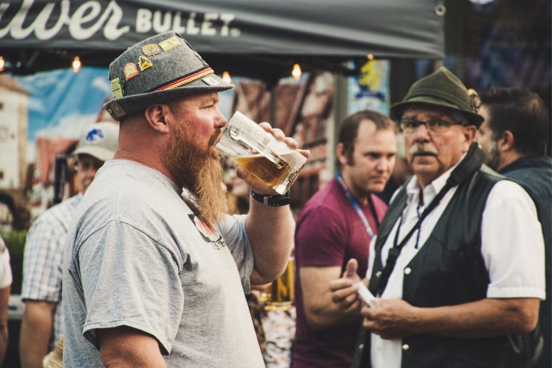 Bearded men drinking beer in a food fair