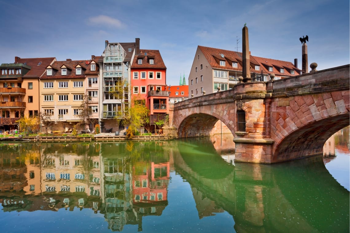 Construcciones coloridas y puente de Nuremberg sobre el río