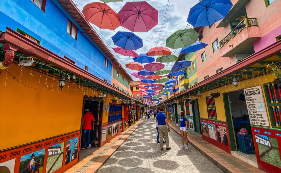 Calle peatonal con paraguas de colores colgados en Guatapé, uno de los mejores destinos para viajar solo en Colombia