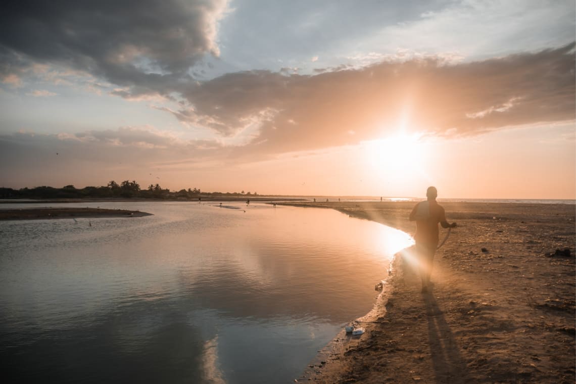 Hombre caminando por la playa de Palomino al atardecer