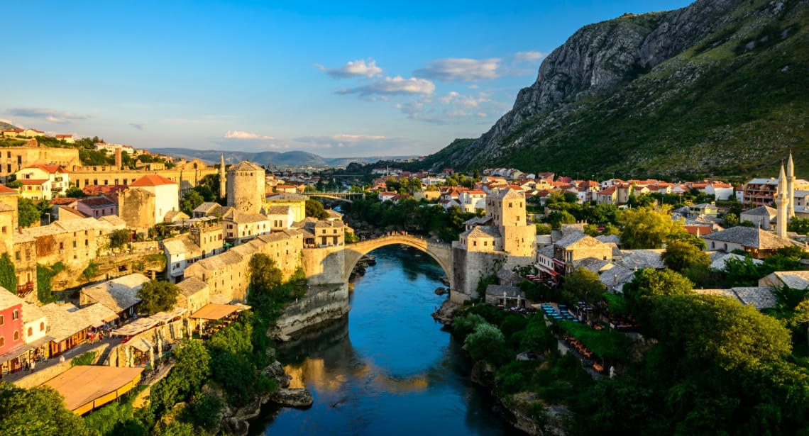 Wide view of historical part of Mostar with stone bridge over a river