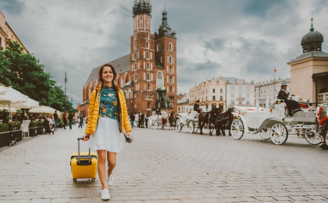 Chica caminando por ciudad colonial con maleta de mano