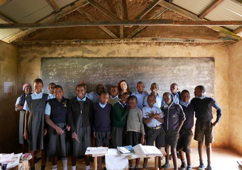 Cultural exchange: Western girl and students from an African rural school posing for a photo