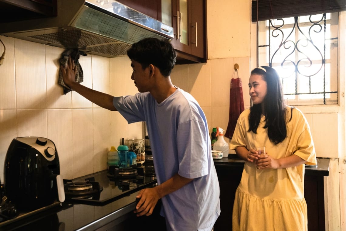 Long term house sitting: Couple cleaning a kitchen