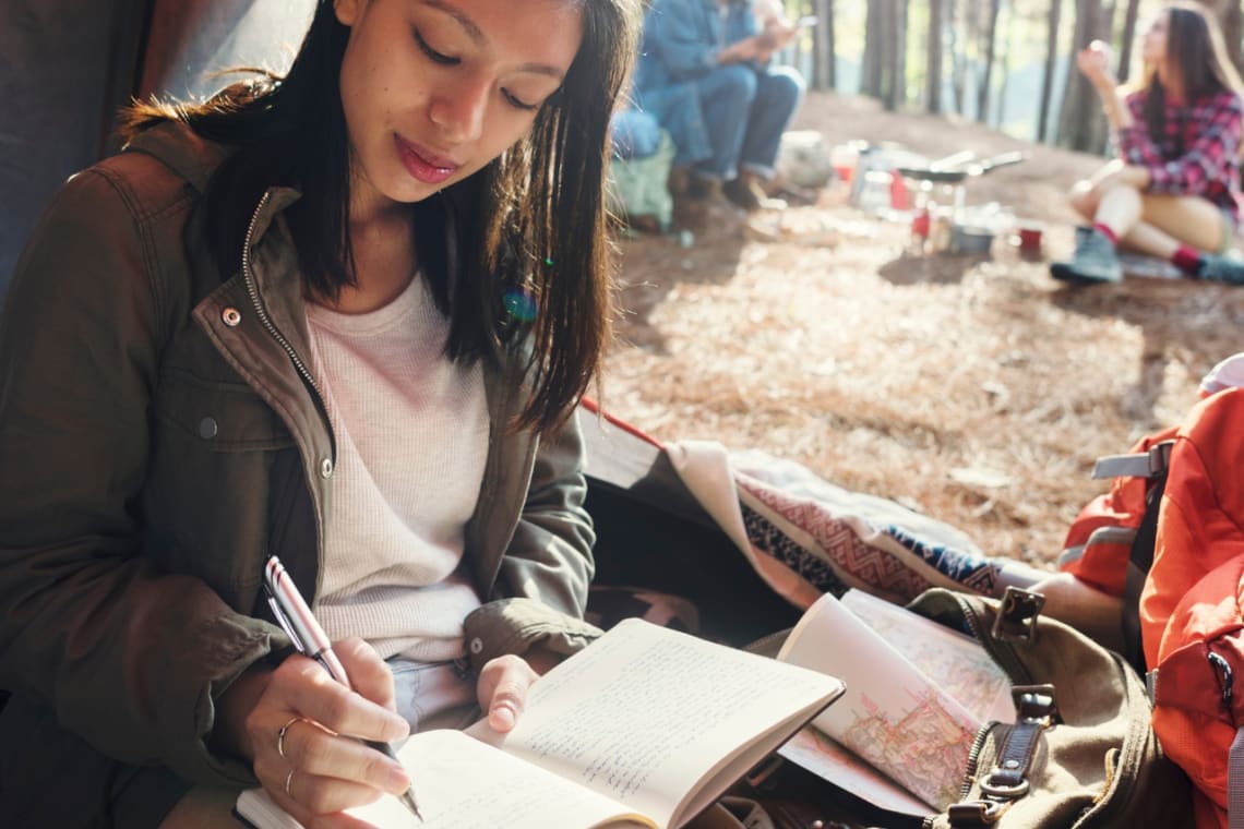 Girl journaling inside a tent 