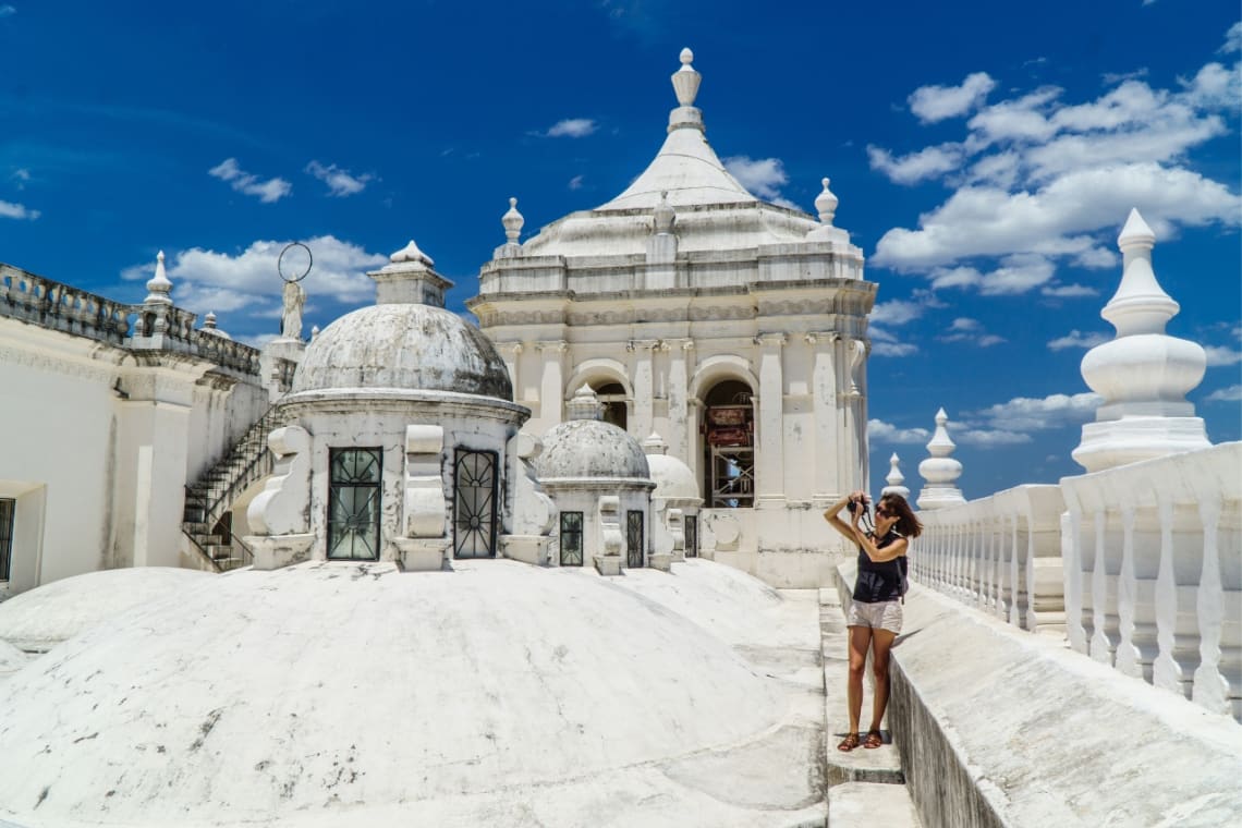 Girl taking a picture at the roof of a cathedral