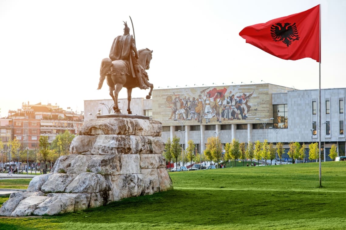 Viajar a Albania: Plaza de Tirana con mástil y monumento de Skanderberg a caballo