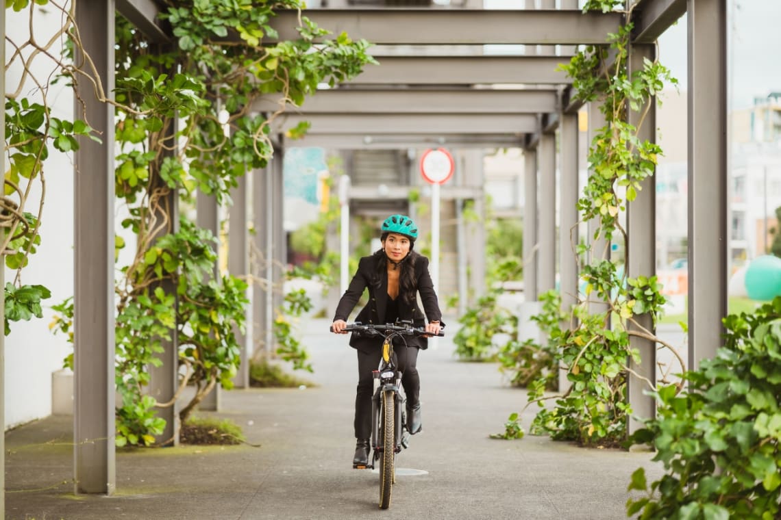 Mujer yendo al trabajo en bicicleta en una ciudad sostenible