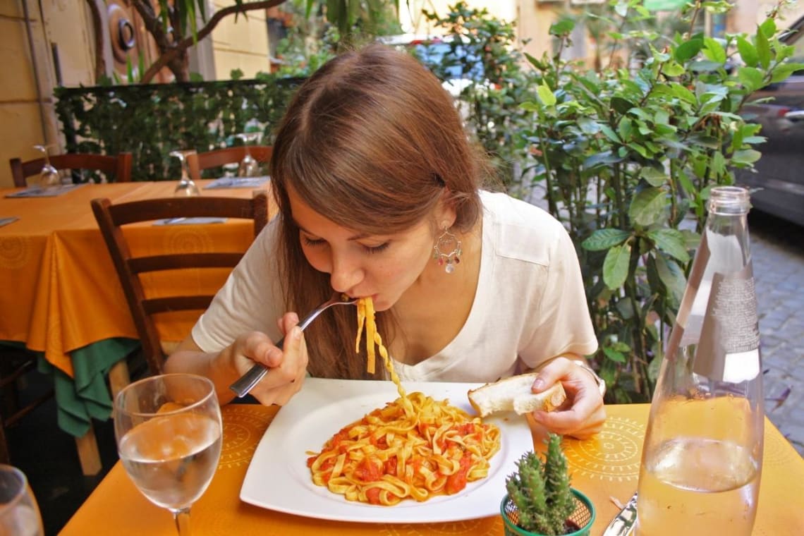 Turismo gastronómico en Italia: chica comiendo pasta