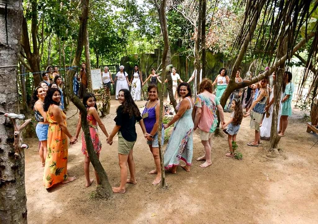 Grupo de mujeres tomadas de las manos formando un círculo en proyecto ambiental de Brasil