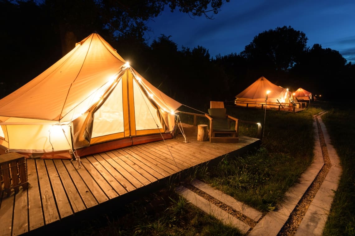 Glamping con tiendas iluminadas en la noche