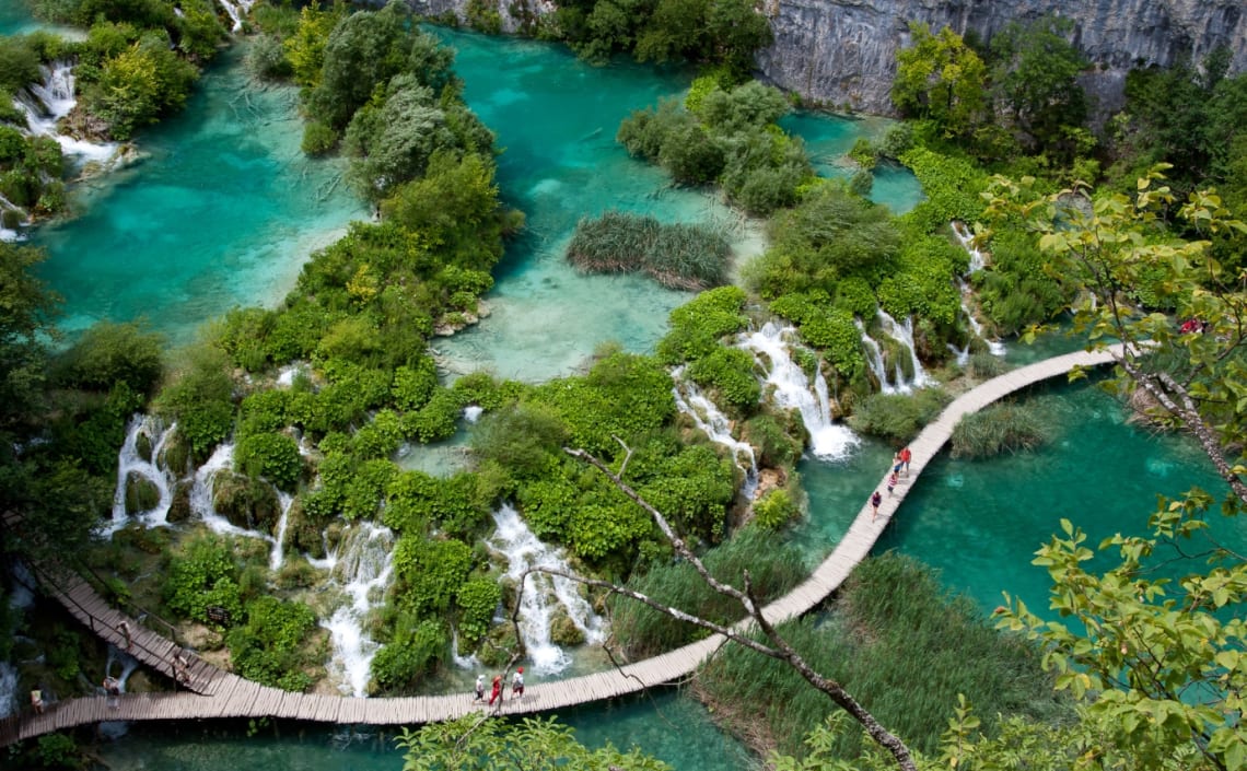 Vista aérea del Parque Nacional Lagos de Plitvice con gente caminando sobre pasarela