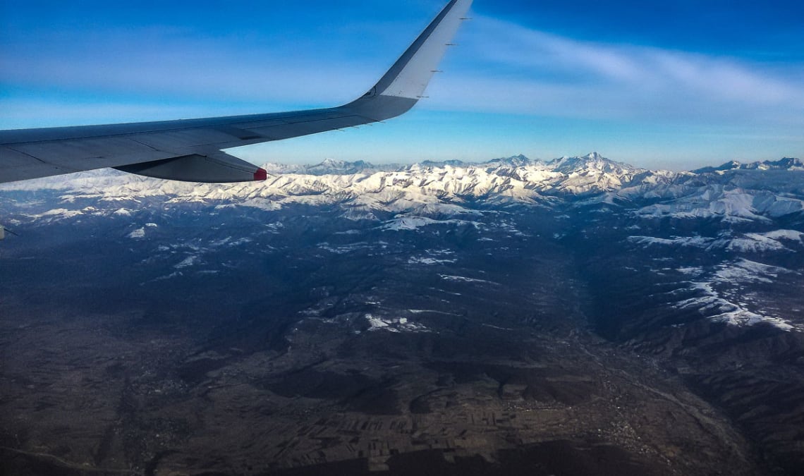 Vista de montañas nevadas a través de la ventanilla del avión