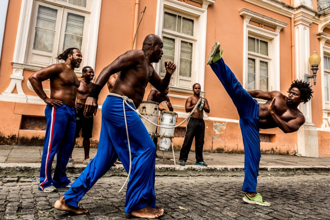 Grupo de hombres practicando capoeira en la calle 