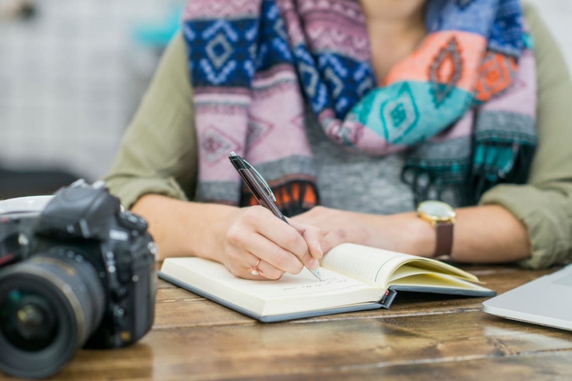 Girl writing down notes on her travel journal