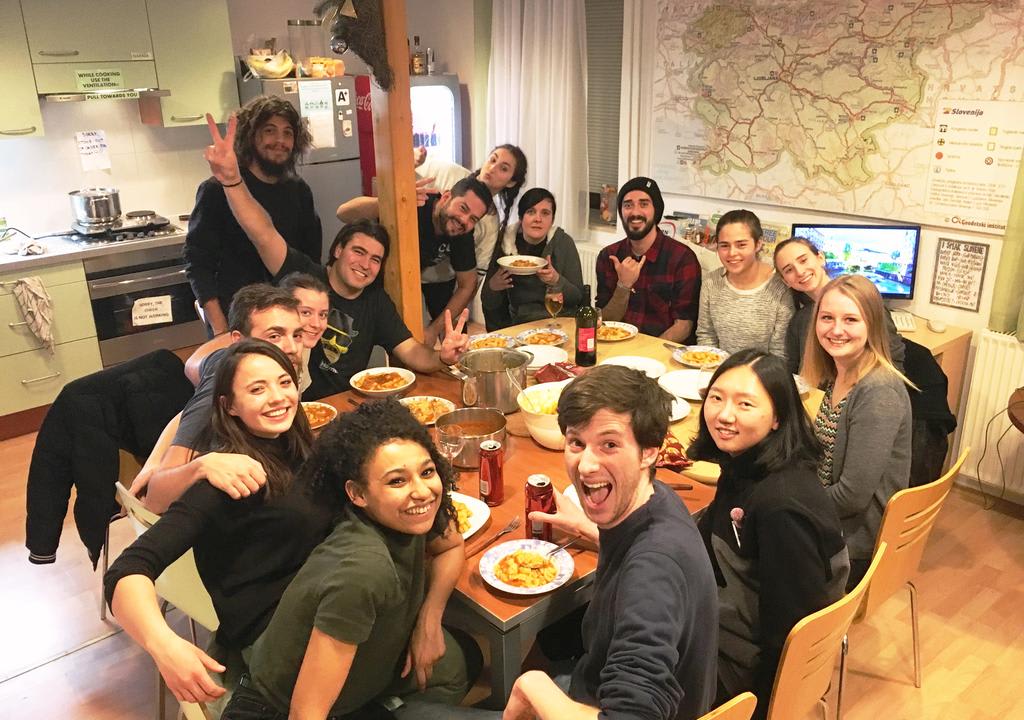 Group of young people eating in the hostel's kitchen