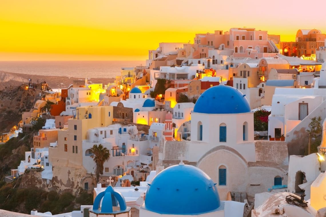 Famosa iglesia de las cúpulas azules y casas blancas de Oia, pueblo turístico de Santorini