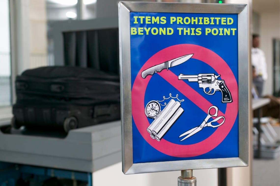 Cartel de ítems prohibidos en equipaje de mano en control de seguridad del aeropuerto