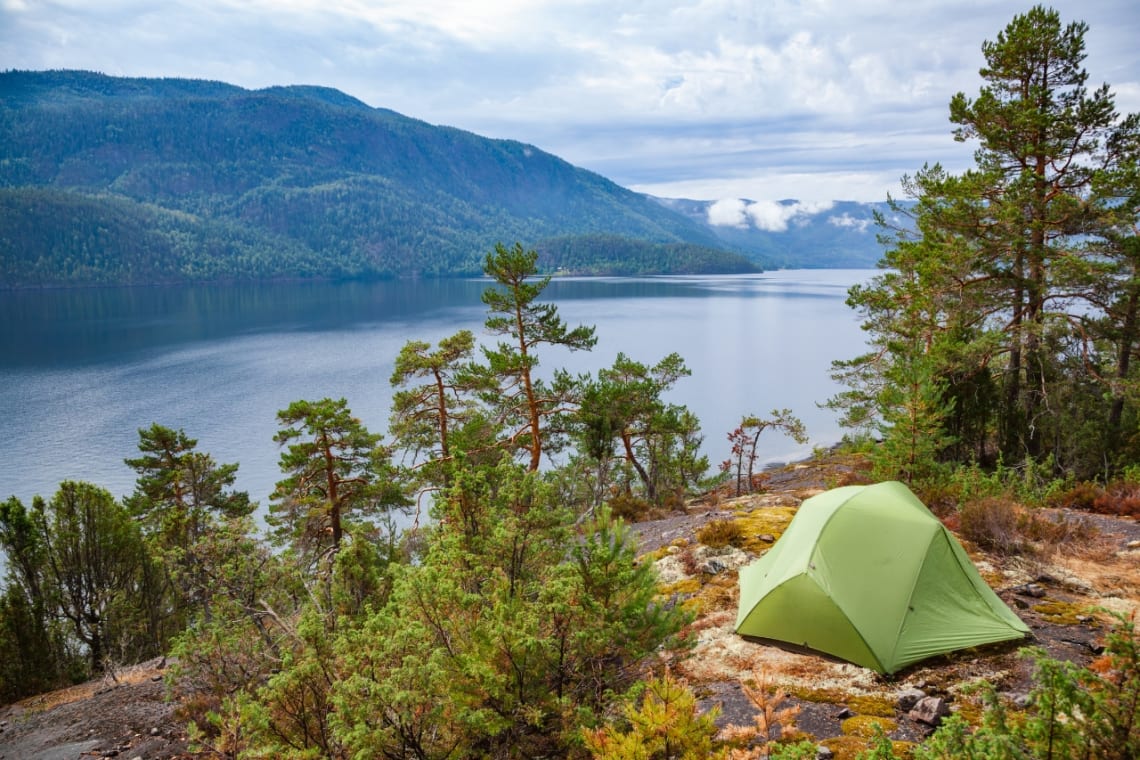 Carpa en lo alto de una colina con vista a un lago