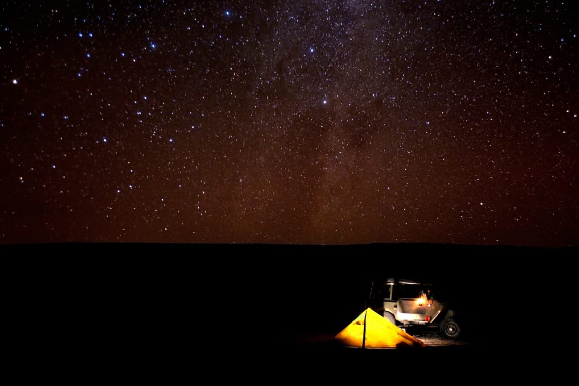 Carpa en la noche con cielo estrellado en el Desierto de Atacama