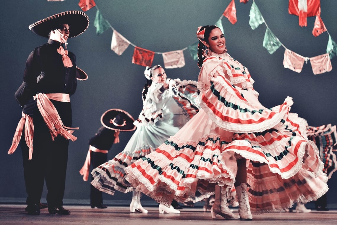 Women and men dressed in traditional style dancing