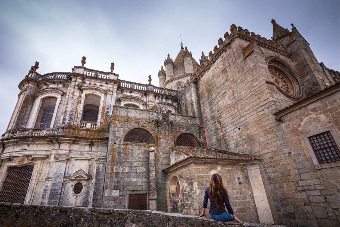 Chica mirando la Catedral de Évora, una de las principales ciudades de Portugal