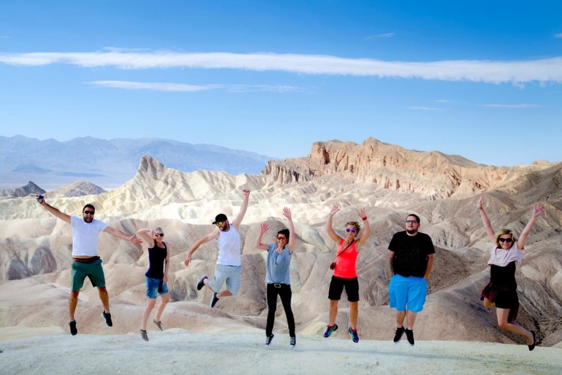 Siete turistas saltando para la foto en el Parque Nacional Valle de la Muerte