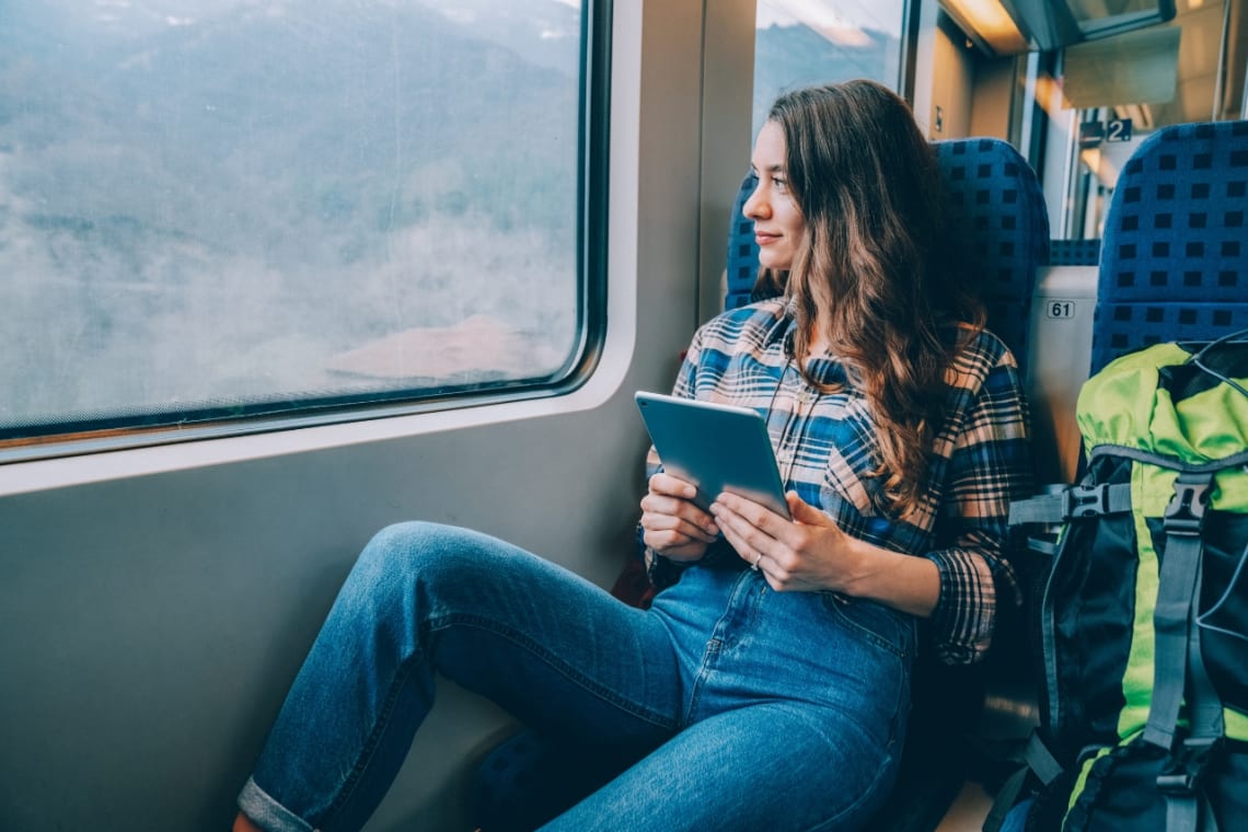 Girl on a train with a backpack as part of her vacation alone