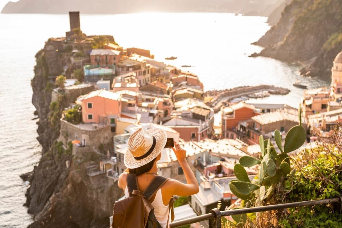 Chica tomando una foto en Cinque Terre, Italia