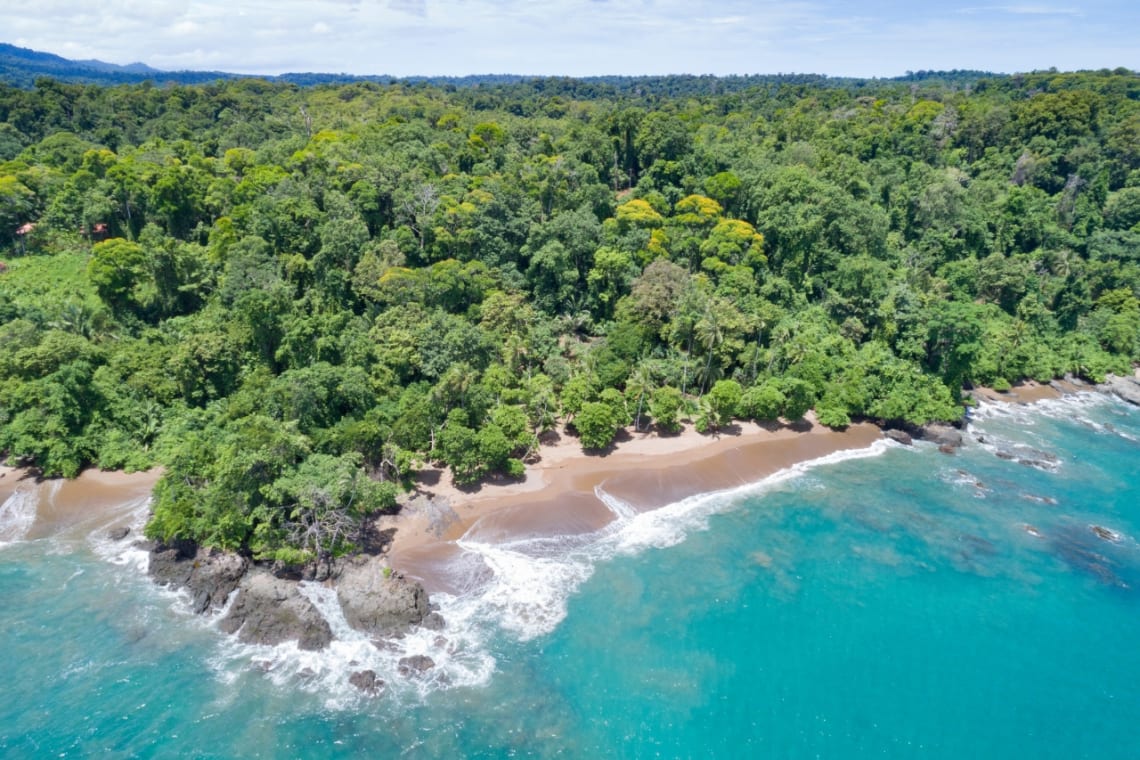 Vista de playa de Costa Rica con agua turquesa y selva